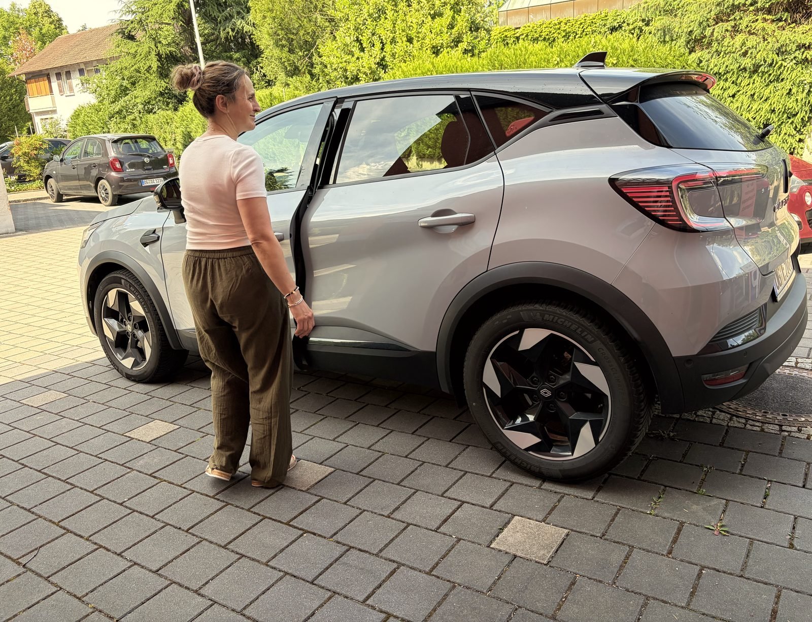 Eine Therapeutin steigt vor der Praxis in ihr Auto, um zu einem Hausbesuch zu fahren